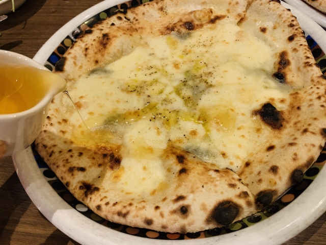 クアトロフォルマッジピザに蜂蜜をかける 青カビチーズと甘みの組み合わせ