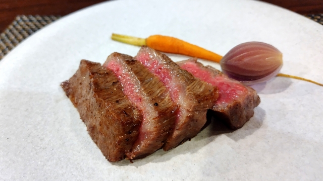 白老牛のサーロインステーキを皿に盛り付けた写真