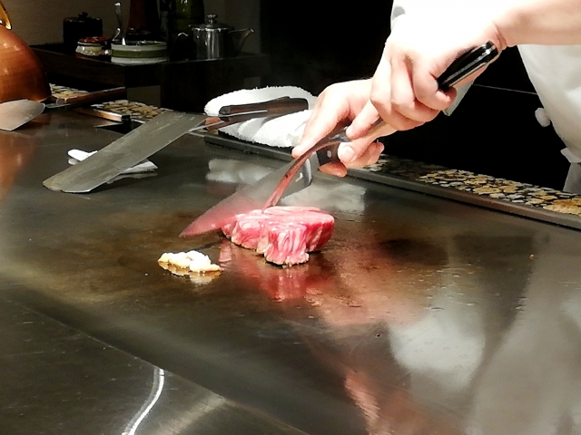 神戸牛ステーキの霜降りと焼き上がりを写した高級感ある料理写真