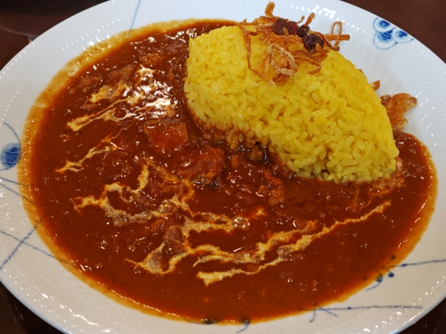 トマトベースのソースで仕上げたハヤシライスと白ご飯の料理写真