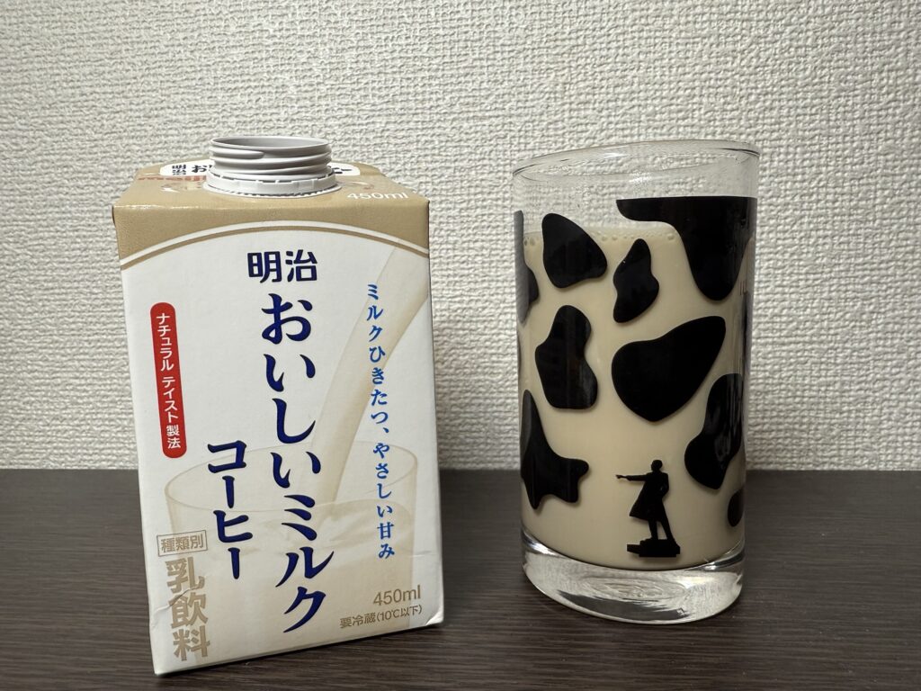 明治おいしいミルクコーヒーをホルスタイン柄のグラスに注いでいる画像
