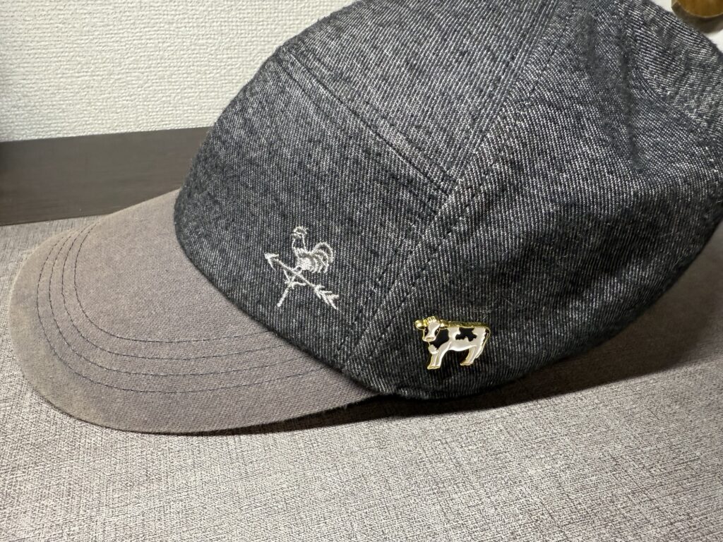 アニマルピンバッジ ウシをキャップの横側に付けたカジュアルコーデ